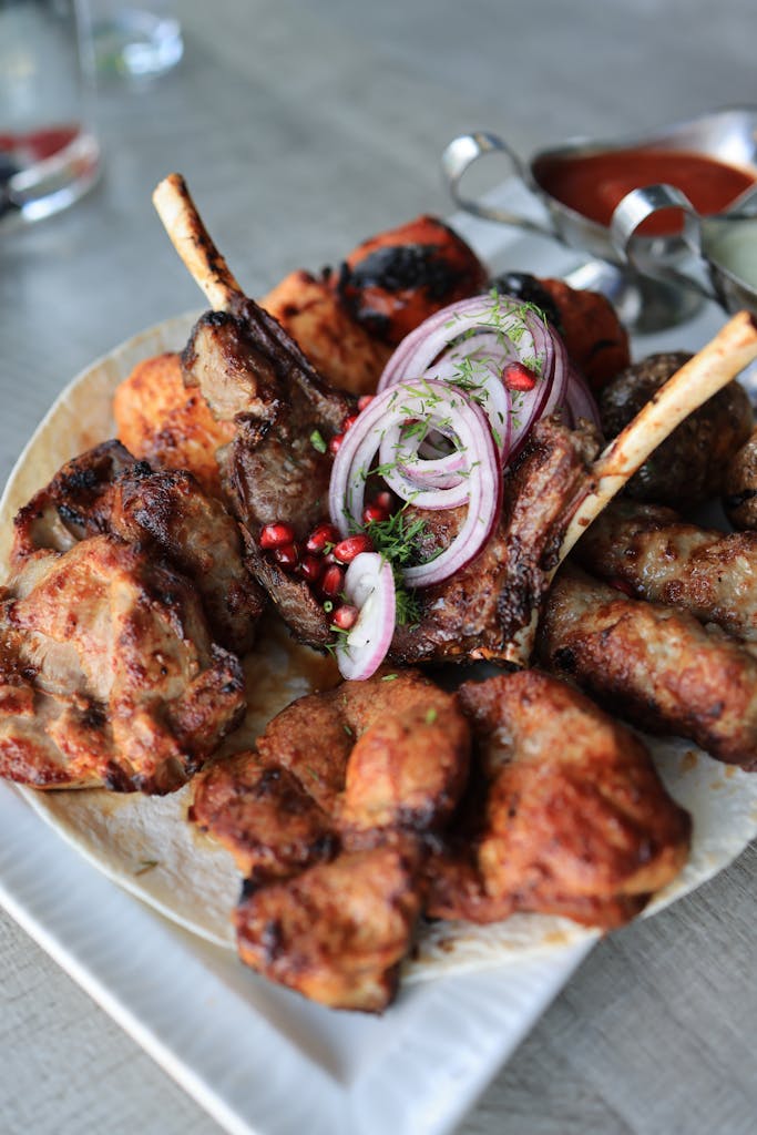 Delicious roasted meat platter with ribs and onions, perfect for a gourmet meal.